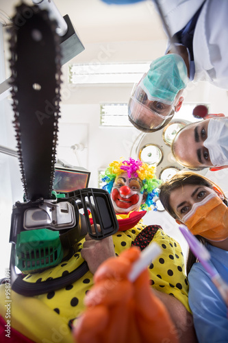 Fotografia Dental nightmare with crazy clown with chainsaw in bottom view