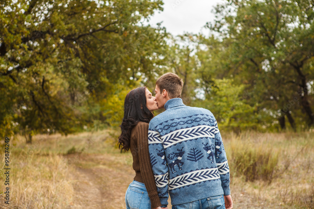Fototapeta premium A loving couple kissing in autumn park outdoors