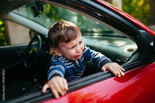 Crying baby boy in car.