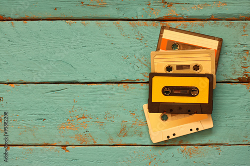 close up photo of vintage cassette tape over aqua wooden table . top view. retro filtered
 photo