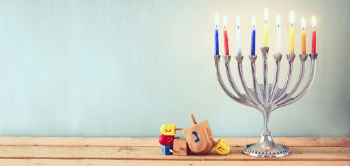 website banner image of of jewish holiday Hanukkah with menorah (traditional Candelabra). retro filtered.