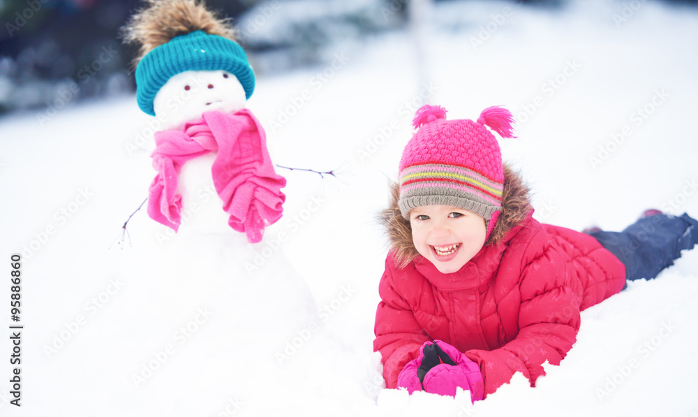 happy child girl with a snowman on a winter walk happy child girl with a snowman on a winter walk