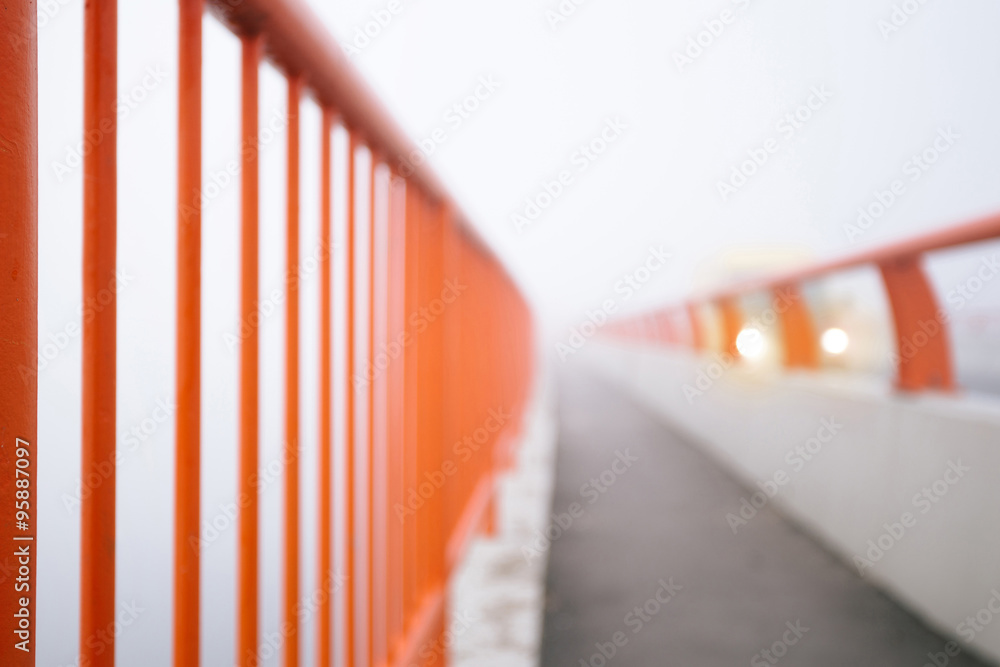 Bridge fence with vehicle lights in background
Bridge fence with vehicle lights in background