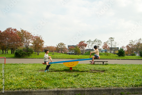 公園のシーソーで遊ぶ子供達