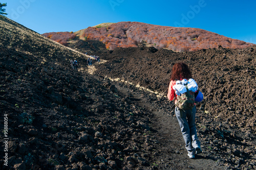 Girl hiker walking on a trail leading to the northern side of Mount Etna