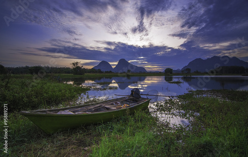 A fisherman's boat near lake shore in sunrise morning photo