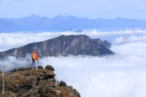 young woman hiker hiking on beautiful mountain peak