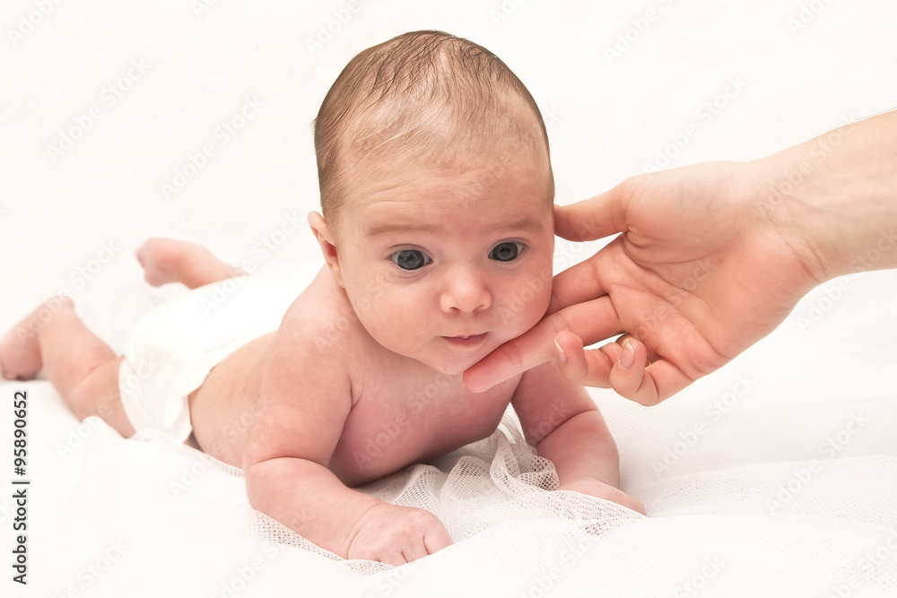 Newborn baby cradled in its mothers hands looking up with a look of wonderment Newborn baby cradled in its mothers hands looking up with a look of wonderment