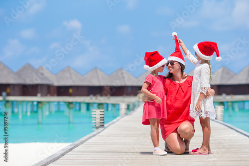 Happy family in Santa hats during Christmas tropical vacation