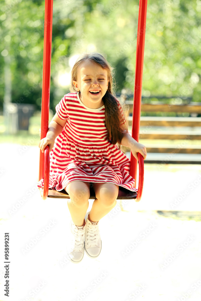 Little girl on swing in the park Little girl on swing in the park