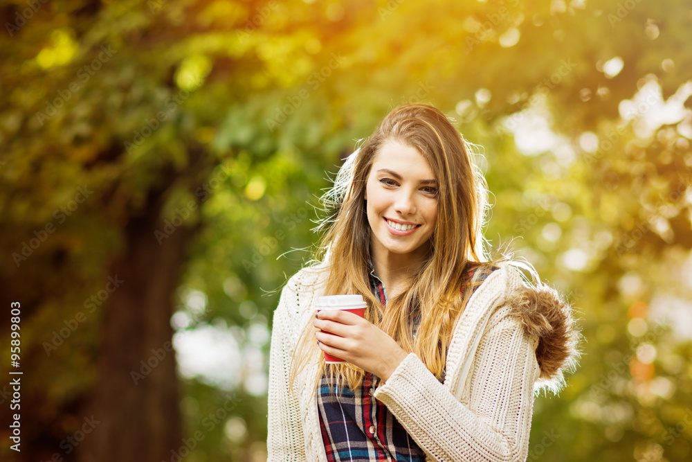 Beautiful young woman with takeaway coffee in autumn Beautiful young woman with takeaway coffee in autumn