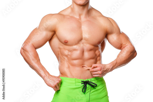 Sexy athletic man showing abdominal muscles without fat, isolated over white background. Muscular male fitness model abs
