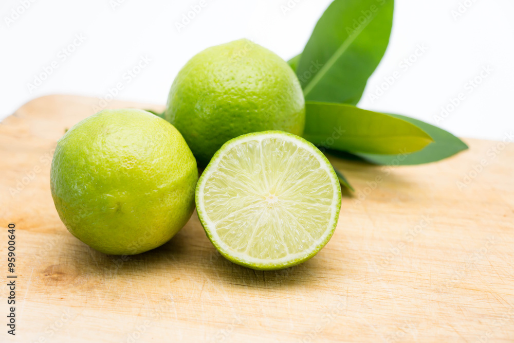 lemon and leaves on wooden cutting board on white lemon and leaves on wooden cutting board on white