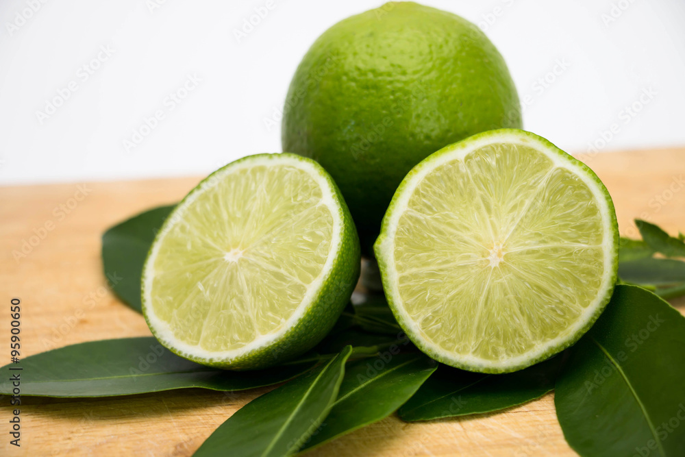lemon and leaves on wooden cutting board on white lemon and leaves on wooden cutting board on white
