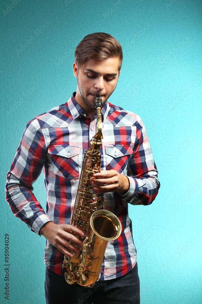 Naklejka premium Saxophone player on blue background
