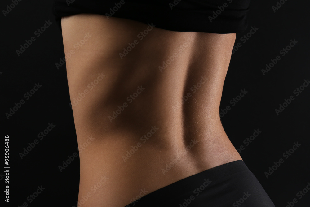 Naklejka premium Slim female body in nice black lingerie on dark background