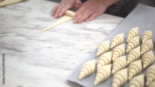 Close up of hand preparing croissant for baking