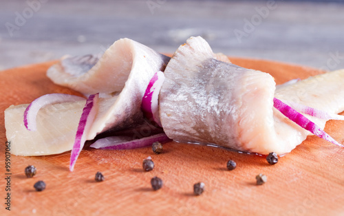 Pieces of herring fillet on a cutting board photo