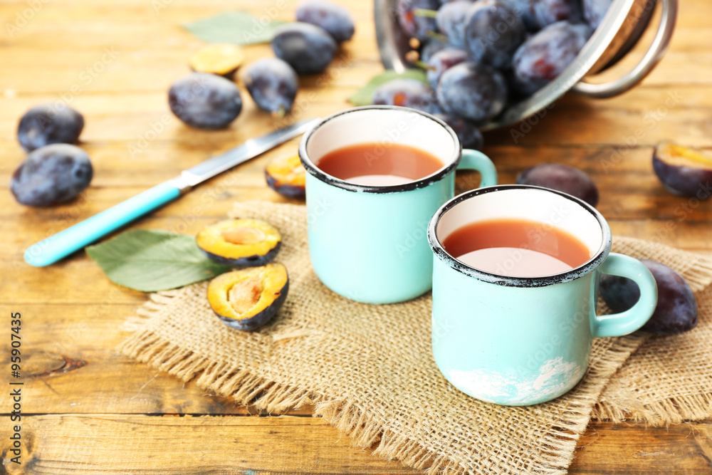 Plum Juice in mugs with fresh fruits Plum Juice in mugs with fresh fruits