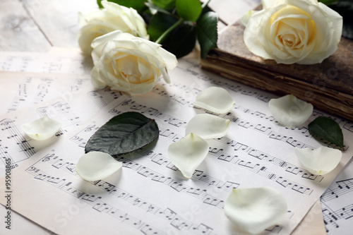 Beautiful rose on music sheets background