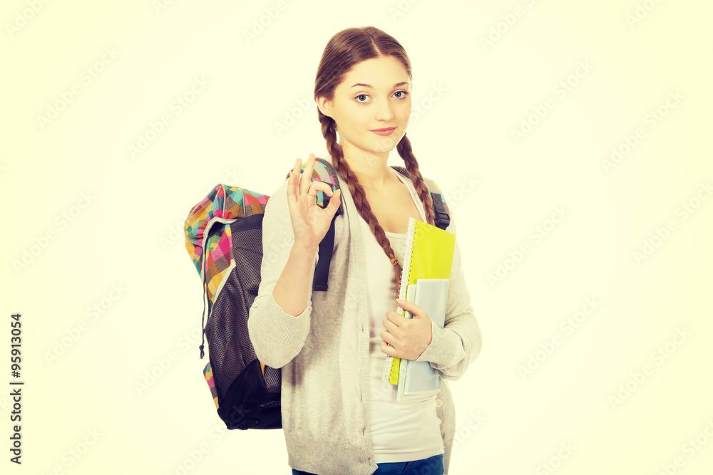 Teen woman with backpack showing perfect sign. Teen woman with backpack showing perfect sign.
