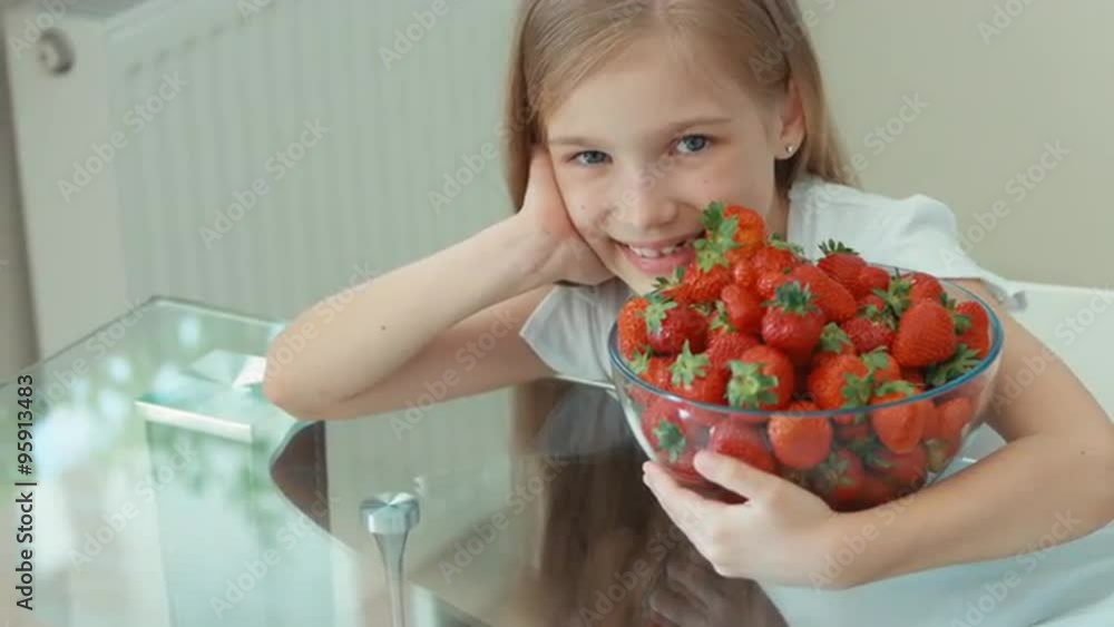 Girl hugging big plate of strawberries and laughing at camera Girl hugging big plate of strawberries and laughing at camera