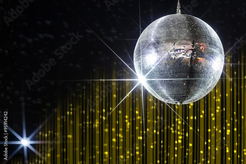 Disco ball with stars in nightclub with striped yellow and black walls lit by spotlight, party and nightlife entertainment industry