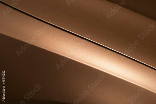 Surface of bronze sport sedan car, detail of metal hood and fender of vehicle bodywork 