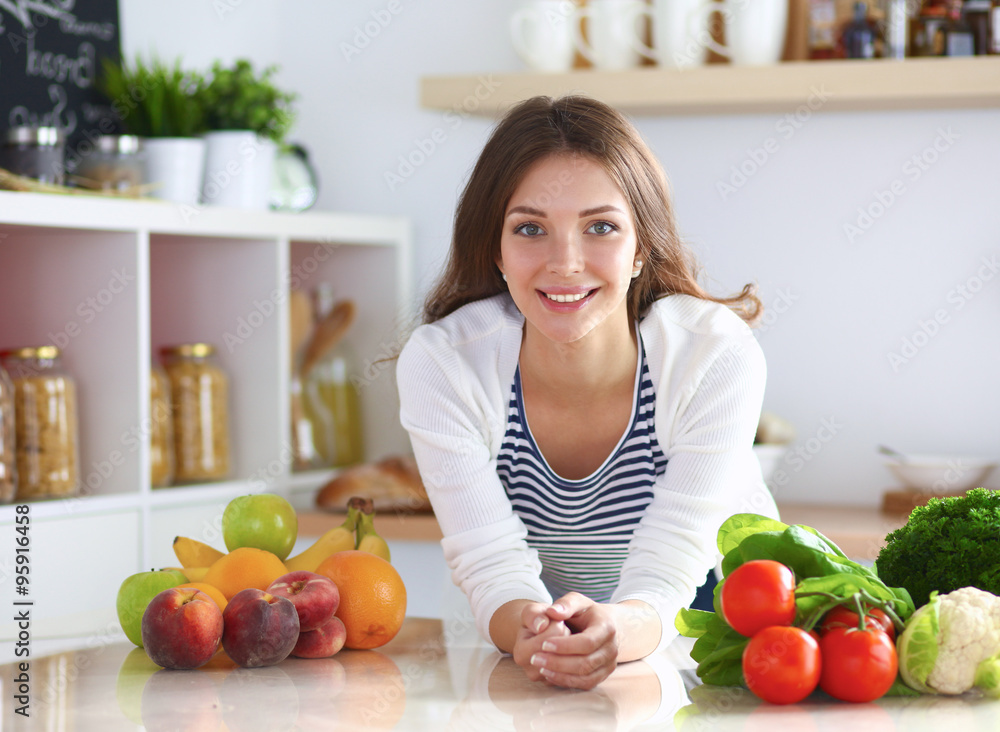 Young woman standing near desk in the kitchen Young woman standing near desk in the kitchen