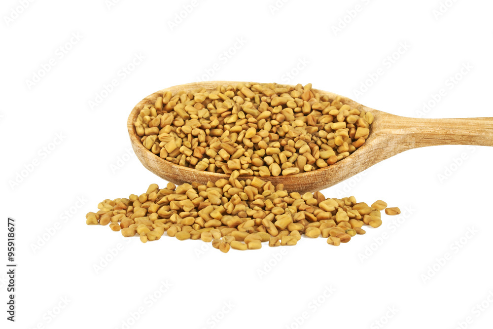 Fenugreek seeds in wooden spoon isolated on white background Fenugreek seeds in wooden spoon isolated on white background