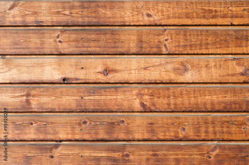 Naklejka premium Larch wooden planks on the building facade covered with preventive impregnation