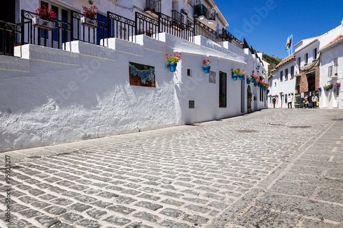 Cuadro en lienzo Picturesque street of Mijas with flower pots in facades. Andalus