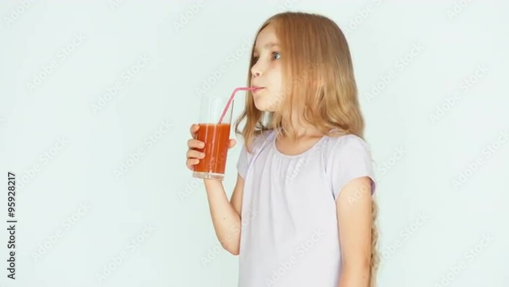 Girl drinking red orange mandarin juice and laughing at camera. Girl with beautiful blonde hair on a white background. Thumb up. Ok Girl drinking red orange mandarin juice and laughing at camera. Girl with beautiful blonde hair on a white background. Thumb up. Ok