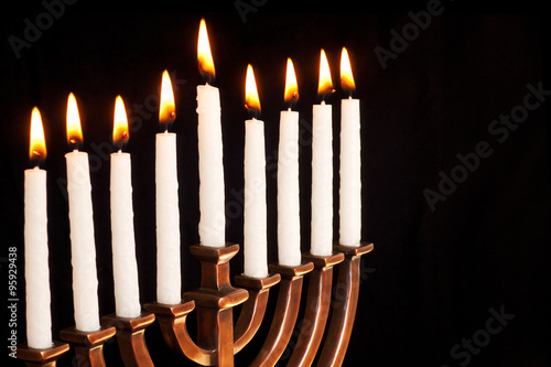 Beautiful lit hanukkah menorah on black background.