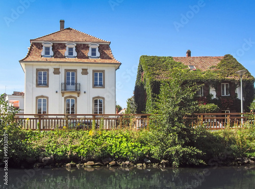 Old antique house covered with green ivy on river side