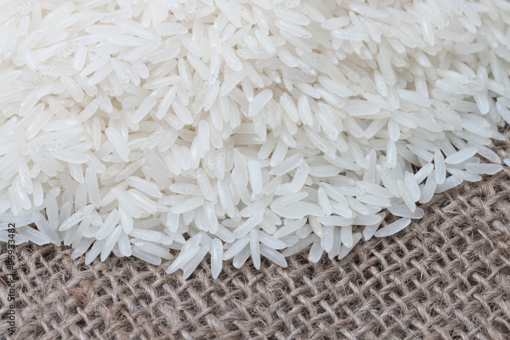 Uncooked white rice (Jasmine Rice)on brown sack. Uncooked white rice (Jasmine Rice)on brown sack.