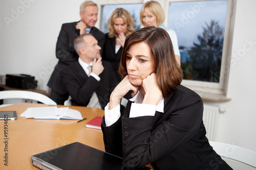 Junge Businessfrau mit Team im Hintergrund