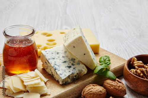 four cheeses with supplements closeup on wooden board photo