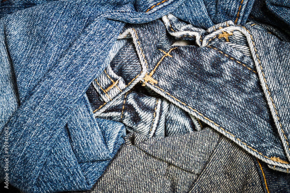 Close up of texture of many jeans trouser stack background