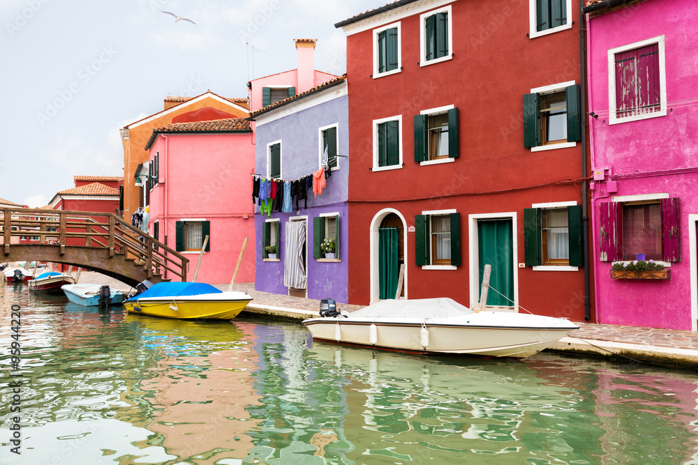 Multi-colored walls of houses and motor boat on Burano's island, Venice