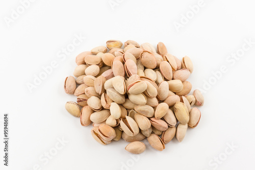 hill of pistachios in a shell lies on a white background