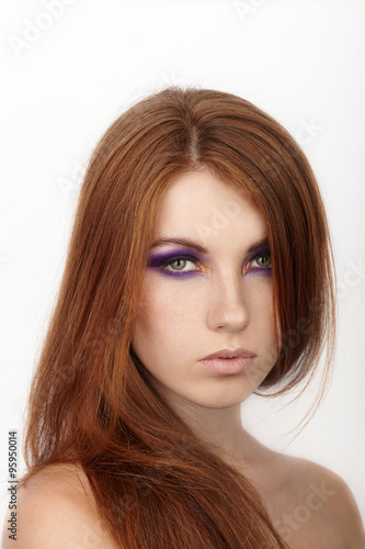 Closeup portrait of young calm beautiful redhead woman with gorgeous hair and violet eyes makeup