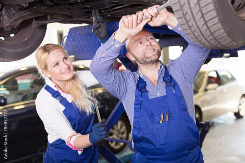 mechanic and assistant working at auto repair shop © JackF