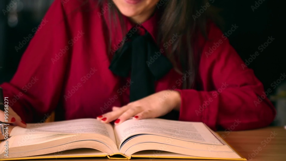 Young woman with red shirt and black tie reading a book Young woman with red shirt and black tie reading a book
