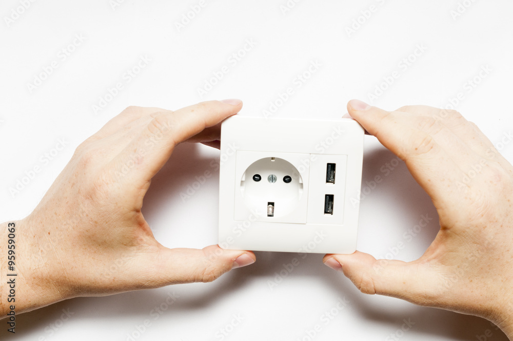 A man hold the electric socket with two usb-charger ports. A man hold the electric socket with two usb-charger ports.