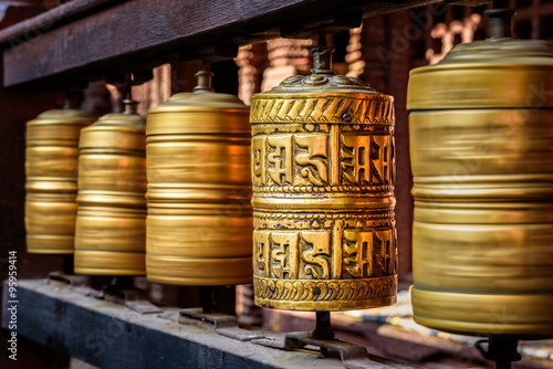 Foto Golden tibetan prayer wheels in a Buddhist temple in Nepal