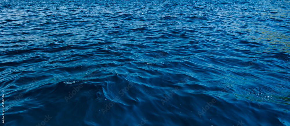 Naklejka premium bliska powierzchni niebieskiej wody w głębokim oceanie