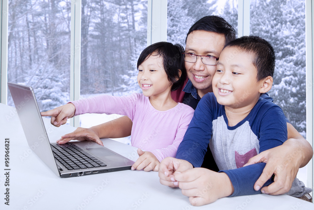 Cute kids watching movie on laptop with dad Cute kids watching movie on laptop with dad