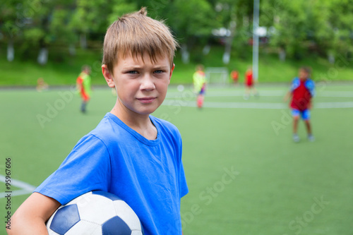 Boy footballer with a ball in a stadium