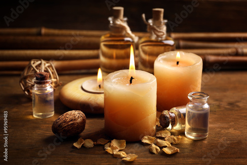 Beautiful decorated composition with candles  pebbles and bamboo on wooden background